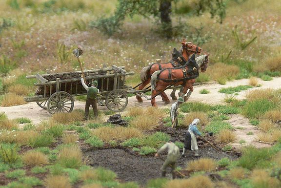Ein Miniatur Modell von Feldarbeitern, die in einem Moor Torf abbauen, welcher dann durch eine von Pferden gezogene Kutsche abtransportiert wird  